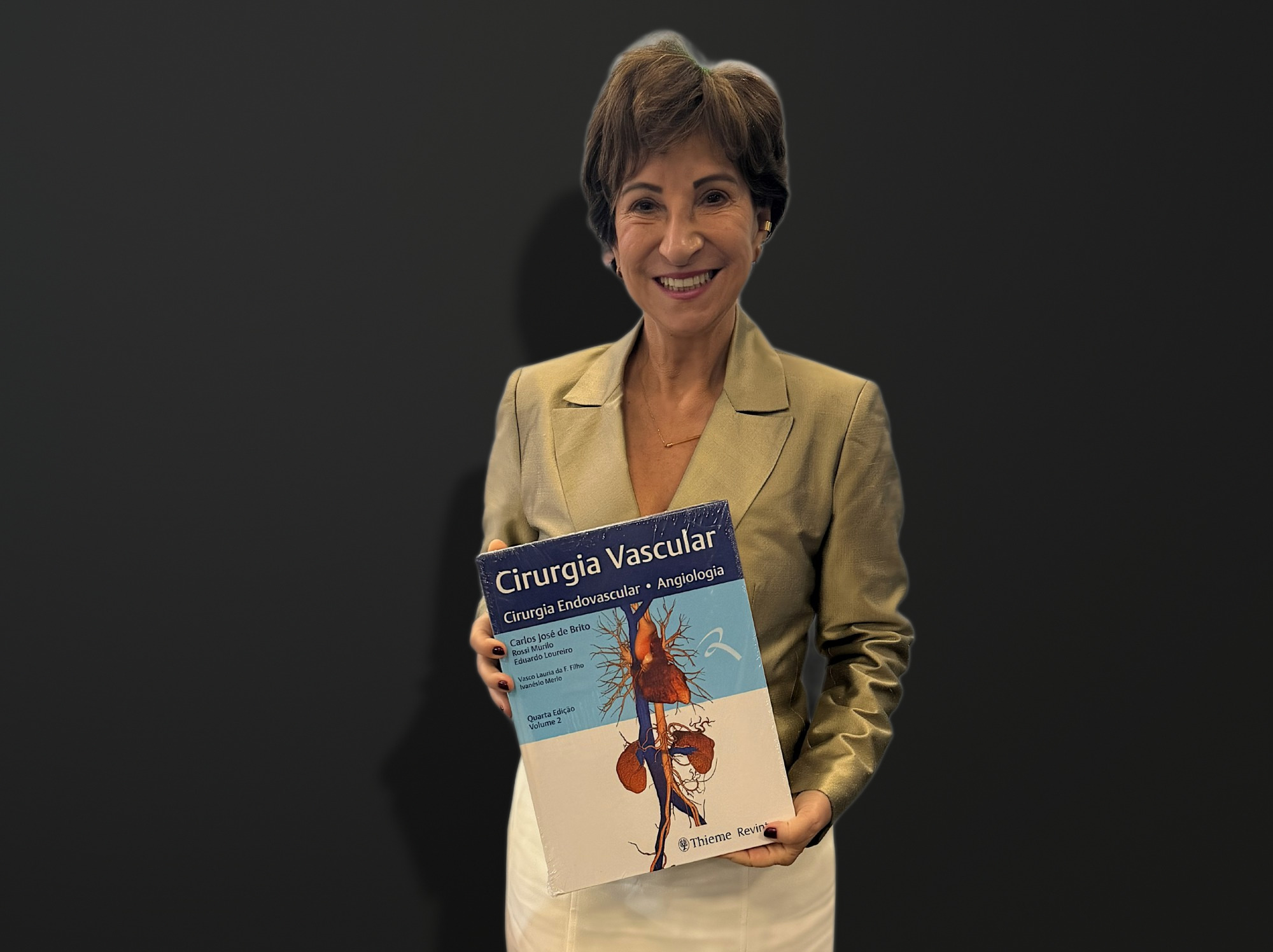 Dra. Fanilda Barros segurando o livro Cirurgia Vascular: cirurgia endovascular e angiologia, quarta edição, volume 2